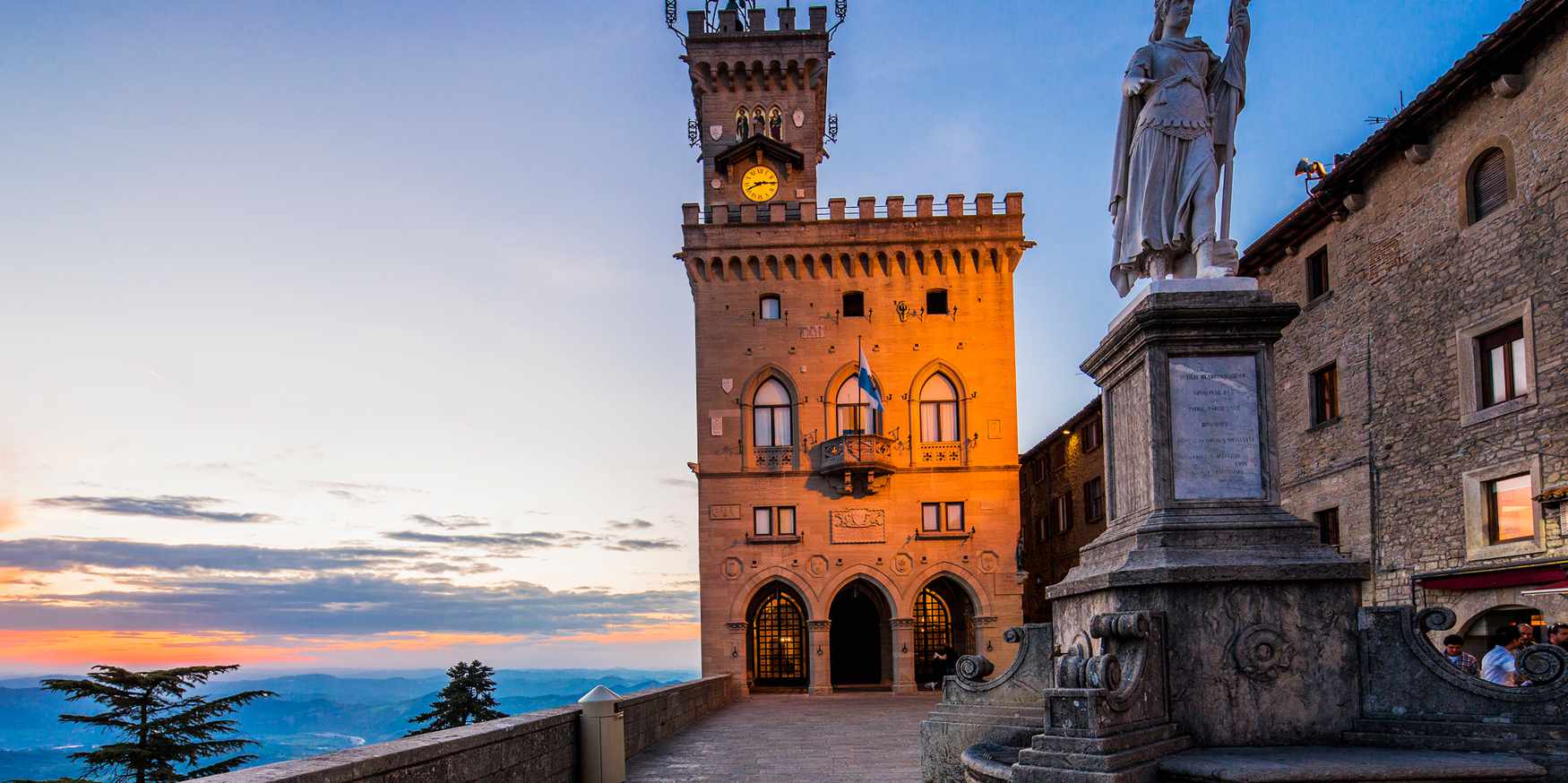 The Palazzo Pubblico (Public Palace, Town Hall) and the Statua della LibertÃ  (Statue of Liberty) by Stefano Galletti (1876) at twilight