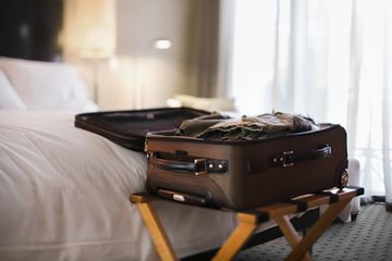 Open suitcase on rack in hotel room