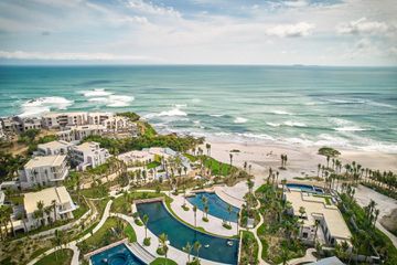 Aerial view of beachside resort in Mexico, palm trees, pools and villas