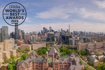 Aerial view of University of Toronto against city skyline with Ontario Legislative Building in the foreground.