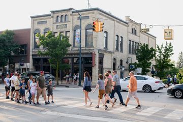 Tourists and locals walk along East Front Street at the heart of downtown Traverse City, Mich