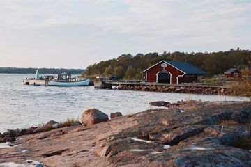 Seaside coast with docked boats and a red boat house 