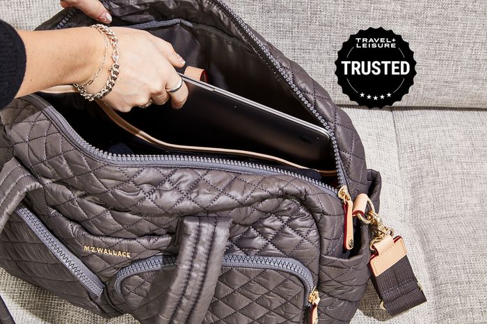 Hand putting a laptop into the MZ Wallace Nik Duffel