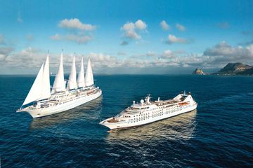 Two Windstar Cruises vessels at sea (one with sails, one without)