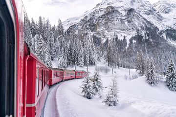 Bernina Express train in the winter forest covered with snow, Preda Bergun, Albula Valley, canton of Graubunden, Switzerland