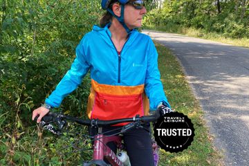 Woman in a windbreaker jacket riding a bike outdoors