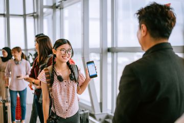 Young girl using phone to check in airport before boarding