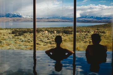 Two people look out at wildlife from a hotel spa pool in Chile