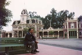 Portrait of American movie producer, artist, and animator Walt Disney (1901 - 1966) as he sits on a bench in his Disneyland amusement park, Anaheim, California, 1950s.