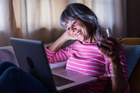 Senior woman using laptop computer to speak to friends from home